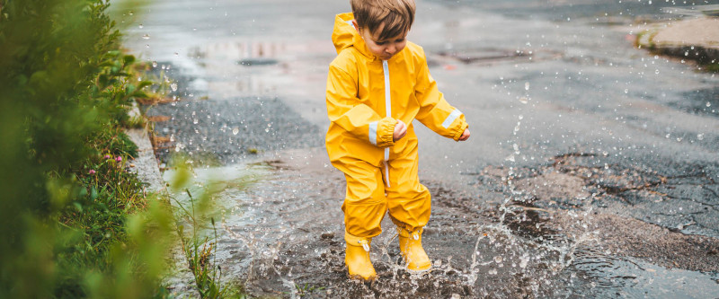 Kind in Regenpfütze