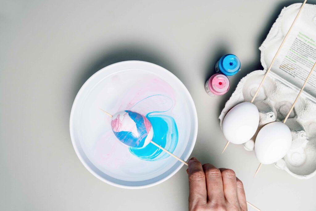 Hier besteht die Technik darin, die aufgespießten Eier so sparsam und zugleich „beherzt“ wie möglich durch die Farb-Wasser-Mischung zu drehen. Jedes wird am Ende anders aussehen.