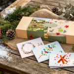 Adventskalender von Saat & Gut aunf einem winterlich dekoriertem Holztisch.