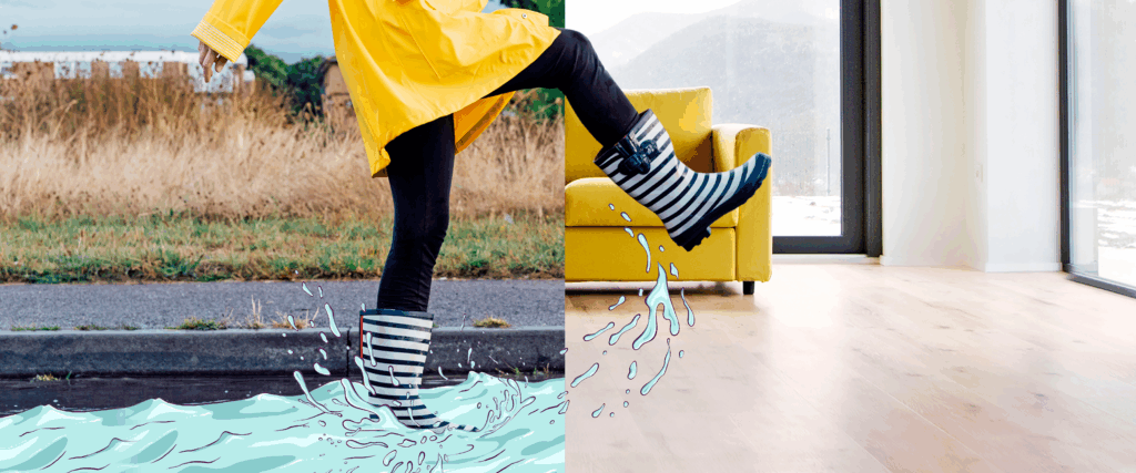 Eine Person stapft mit Gummistiefel von einer Pfütze in auf einen Holzfußboden.