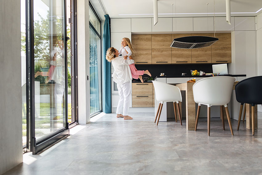 Mutter steht mit Kind im Esszimmer.