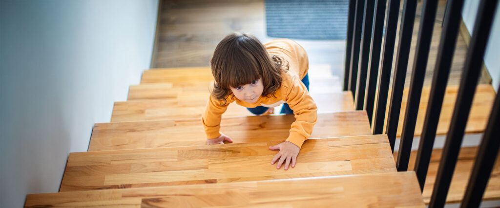 Kleinkind krabbelt eine Treppe hinauf.
